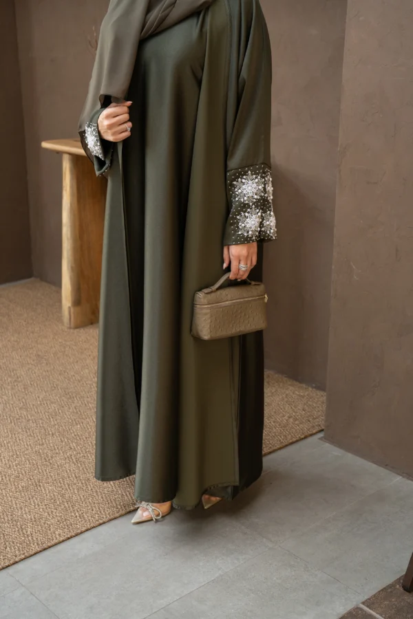 A model in an olive abaya outfit plus the matching scarf