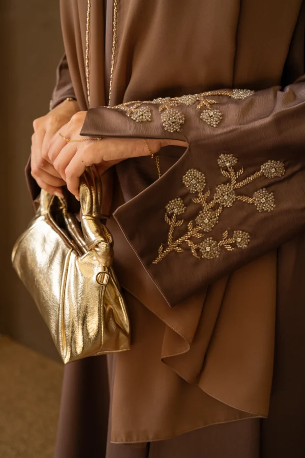 A model in mocha abaya showing off the embellished sleeve