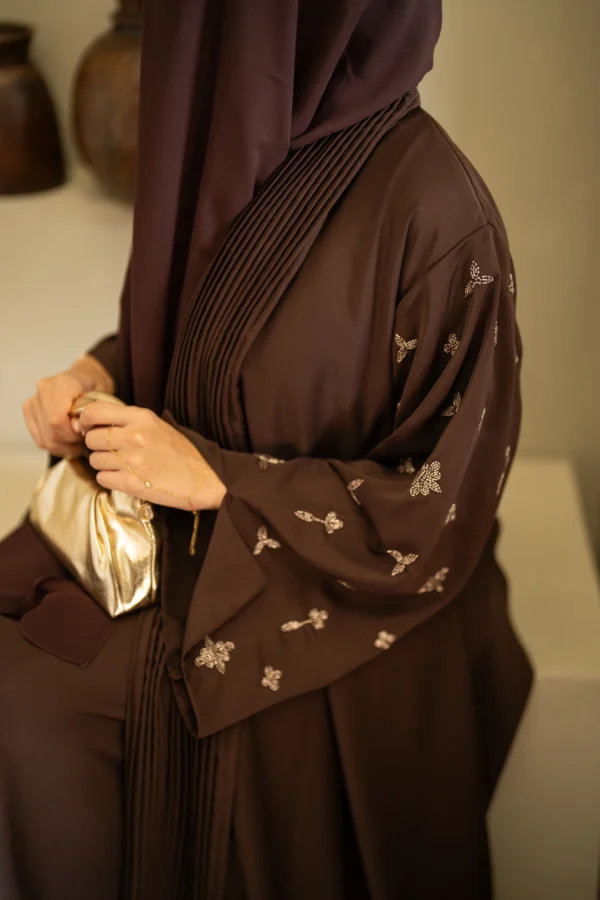 A model sitting down modelling a coffee shade open abaya