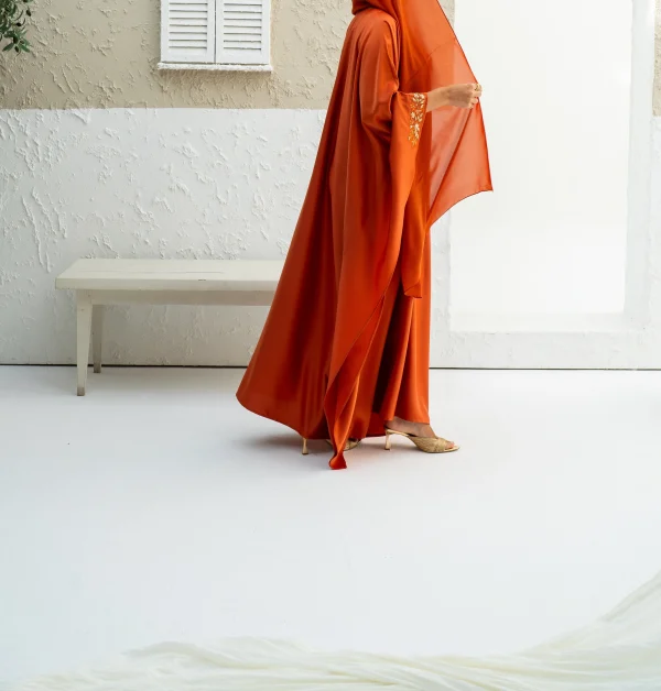 A model in an orange embroidered kaftan dress