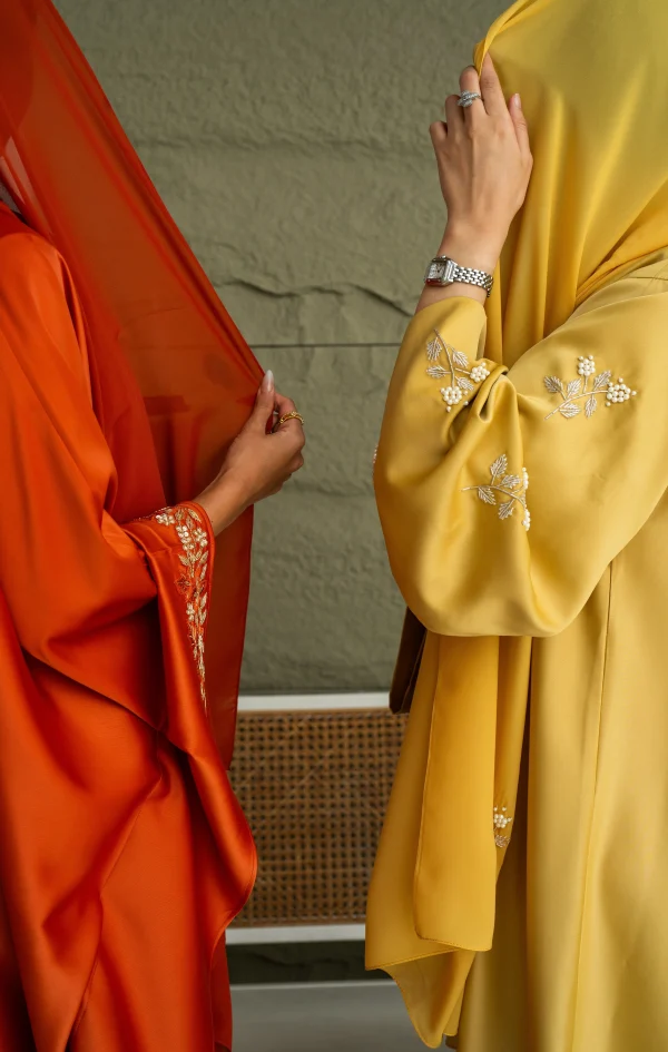 Sleeves of a yellow and orange abaya