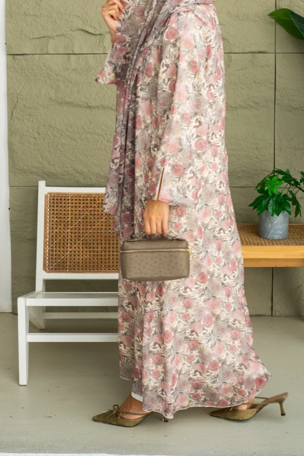 A standing model in a pink chiffon abaya